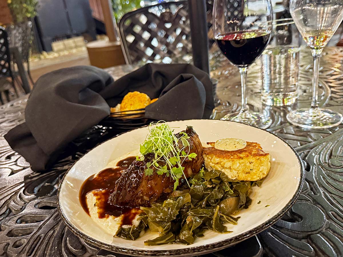 Soby's New South Cuisine offers Southern comfort food with innovative appeal such as this black truffle and parmesan grits, braised local greens, guanciale, gremolata, with rosemary jus. Photo: Carolyn Burns Bass